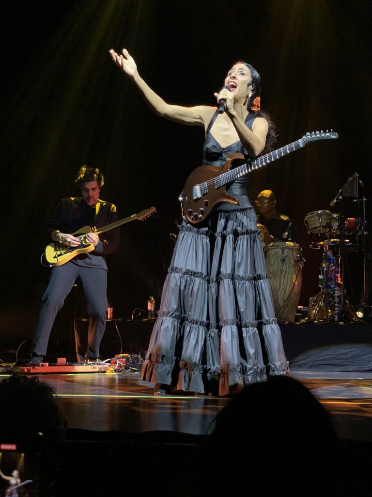Marisa Monte am 10. November 2024 in Brüssel: zu sehen ist die Sängerin im Vordergrund mit einer umgehängten Gitarre, hinter ihr spielt ein weiterer Gitarrist