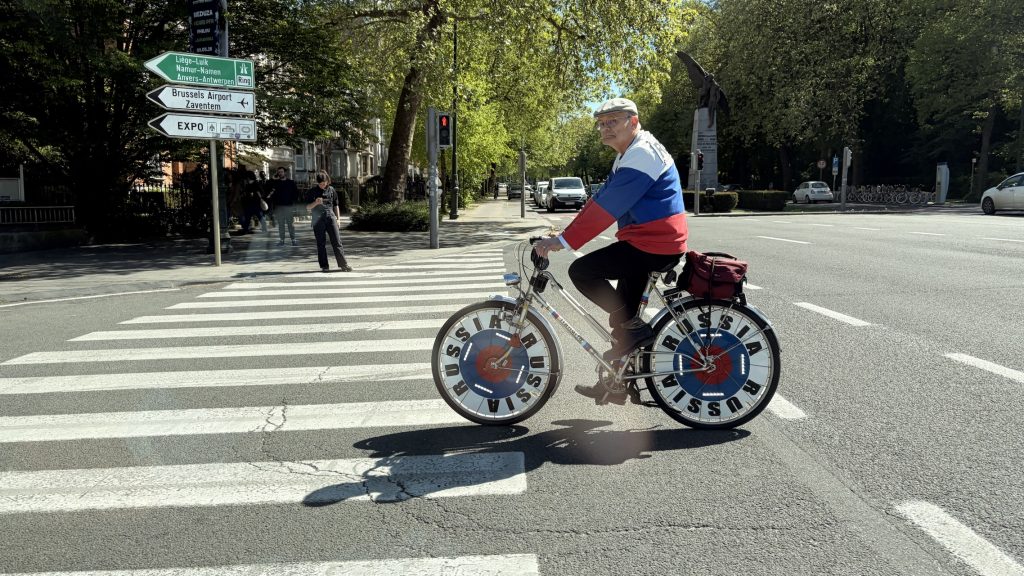 Ein Russland-Fan in Brüssel radelt in den russischen Nationalfarben über eine vielbefahrene Kreuzung im Diplomatenviertel