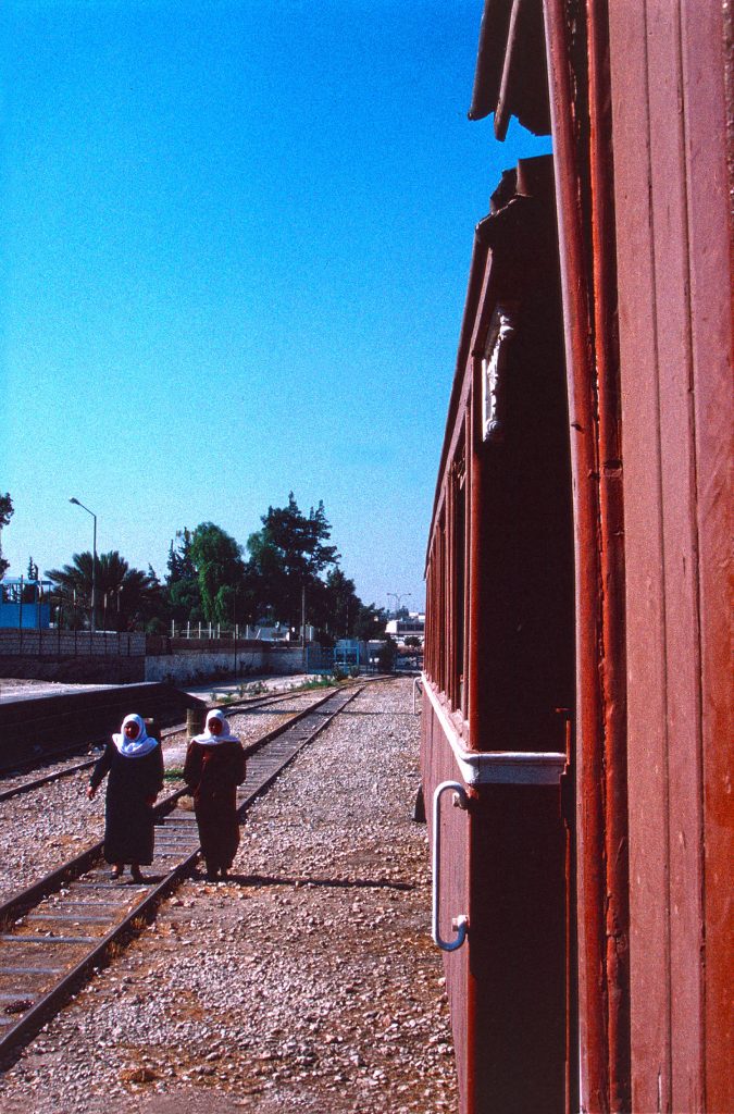 Halt in einem Dorf (1996): zu sehen sind zwei Frauen, die neben dem Waggon auf den Schienen spazieren