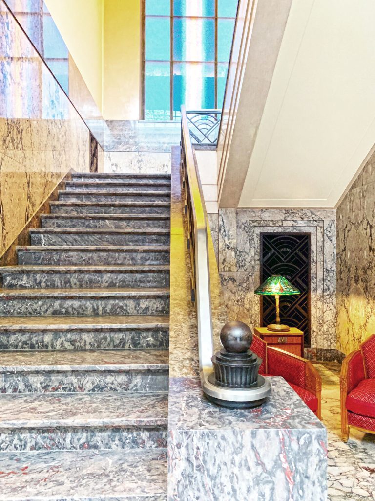 Wenn Treppen zu Skulpturen werden: zu sehen ist eine opulente Treppe mit Messinggeländer und dunklen Marmorstufen