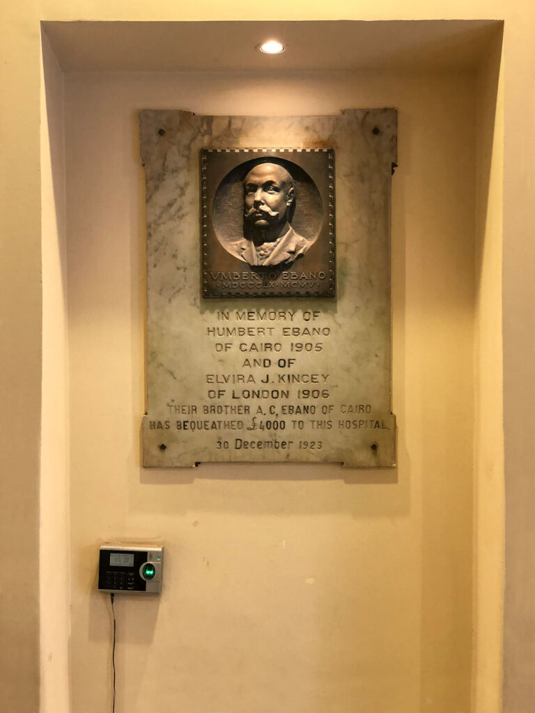 Portrait des italienischen Bankiers Umberto Ebano im Eingangsbereich mit der Aufschrift: „In Erinnerung an Humbert Ebano aus Kairo 1905 und Elvira J. Kincey aus London 1906, deren Bruder A.C. Ebano aus Kairo diesem Krankenhaus £4.000 hinterließ. 30. Dezember 1923.“